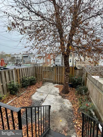a view of backyard with wooden fence and trees