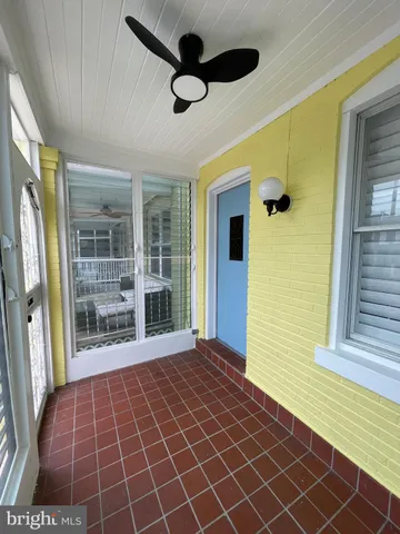 a view of empty room with wooden floor and windows