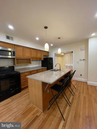 a kitchen with stainless steel appliances granite countertop a stove and a wooden floors