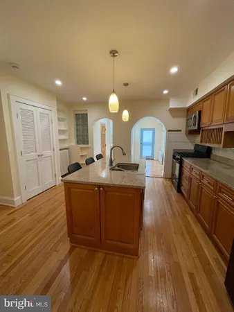 a large kitchen with kitchen island a sink stainless steel appliances and cabinets