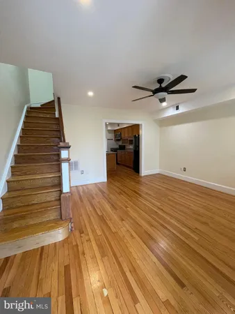 a view of a livingroom with wooden floor and stairs