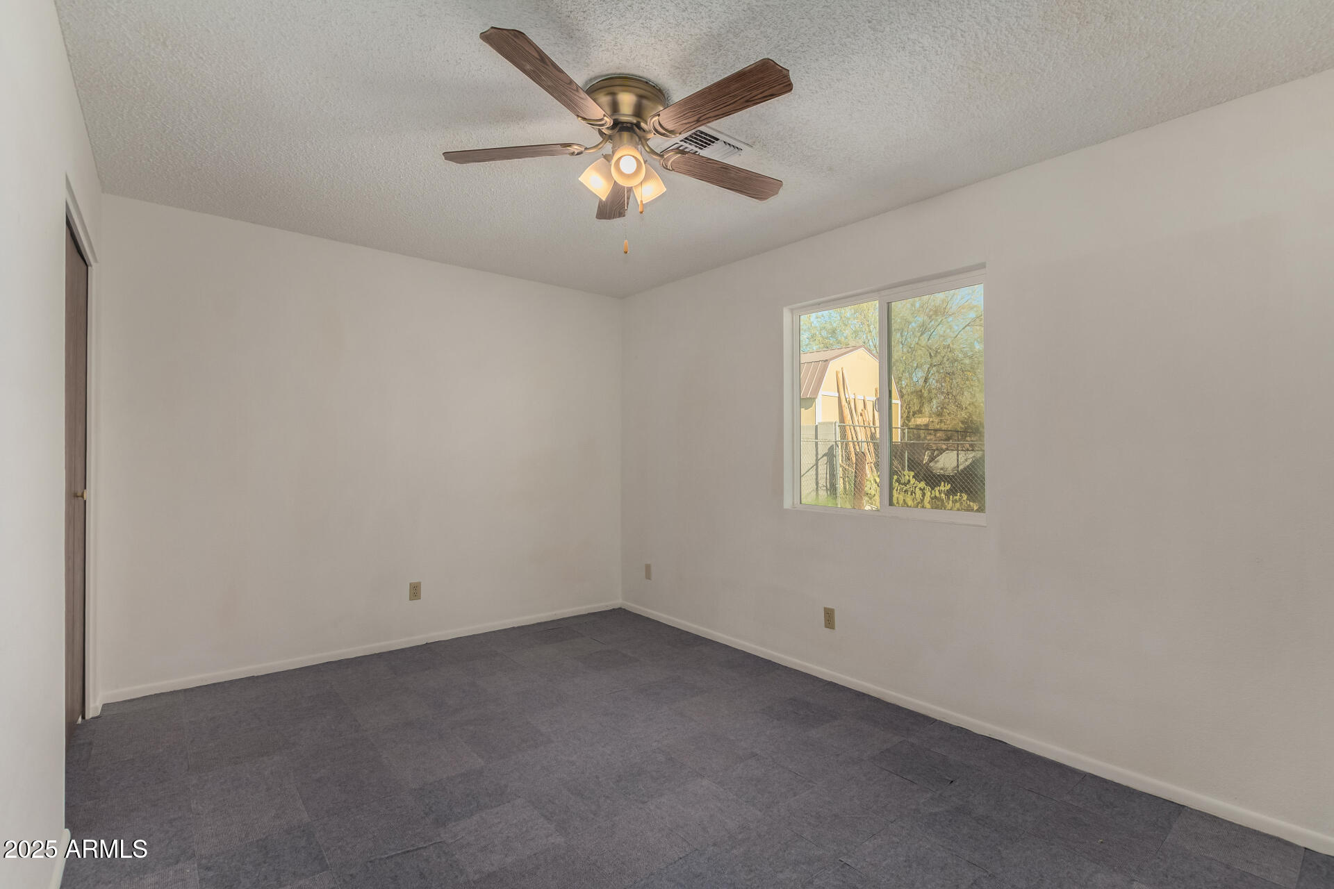 301 South Elmont Drive Apache Junction, AZ 85120 - Photo 15 of 32 an empty room with windows and ceiling fan