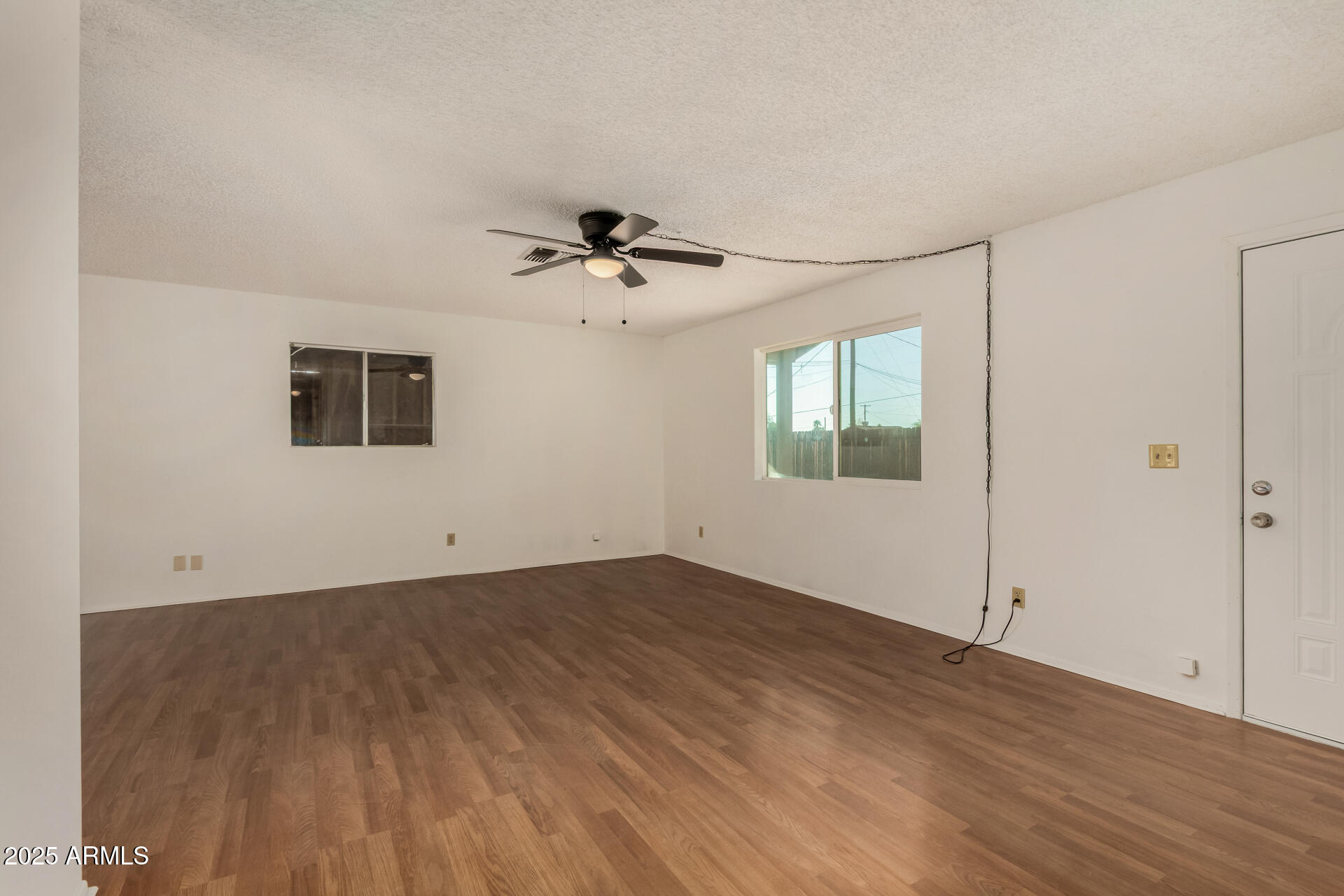 301 South Elmont Drive Apache Junction, AZ 85120 - Photo 4 of 32 an empty room with wooden floor and windows