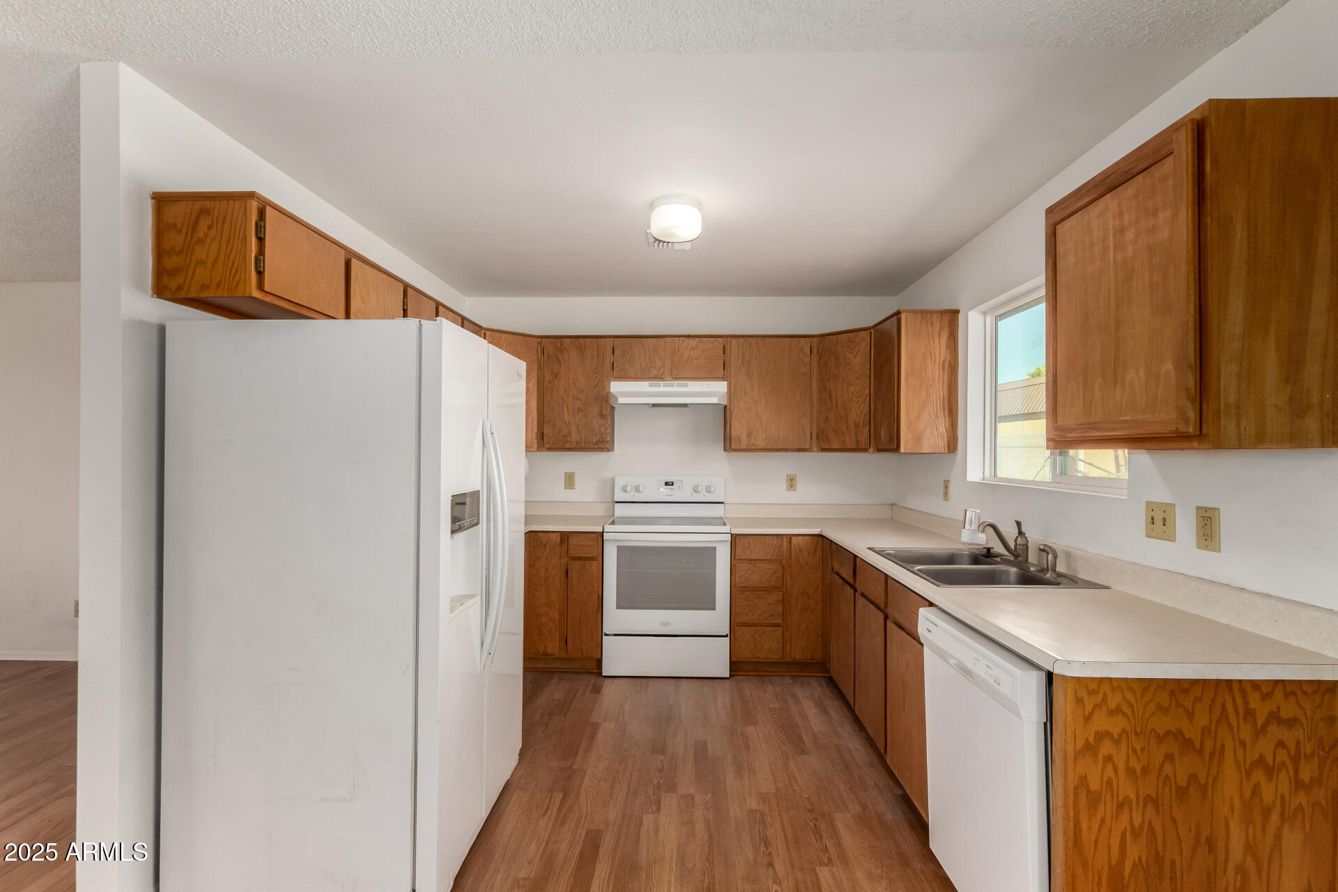 301 South Elmont Drive Apache Junction, AZ 85120 - Photo 7 of 32 a kitchen with a sink a refrigerator a washer dryer and cabinets