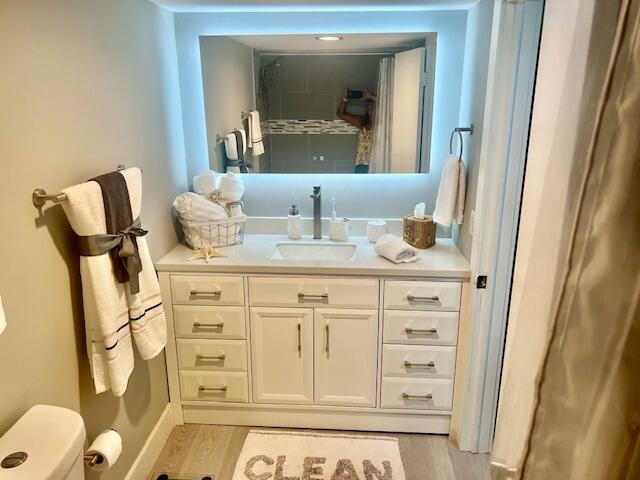 6461 Northwest 2nd Avenue, Unit 409 Boca Raton, FL 33487 - Photo 23 of 61 a bathroom with a sink a toilet and mirror