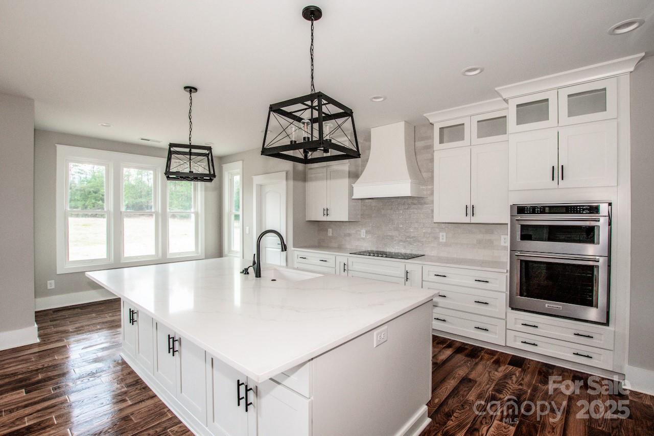 6098 Ballard Road Denver, NC 28037 - Photo 19 of 48 a kitchen with stainless steel appliances granite countertop a sink and a wooden floor