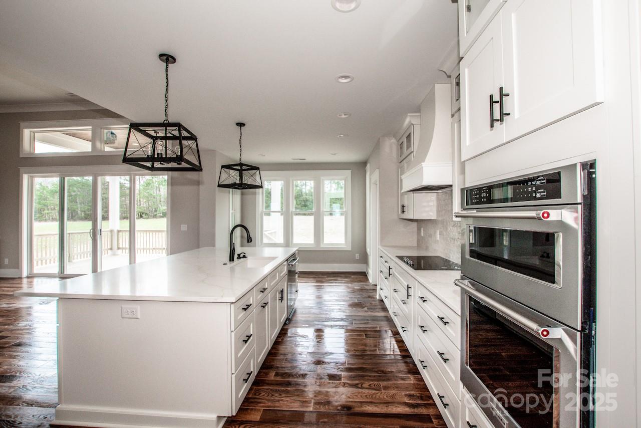 6098 Ballard Road Denver, NC 28037 - Photo 24 of 48 a kitchen with counter top space stainless steel appliances and wooden floor