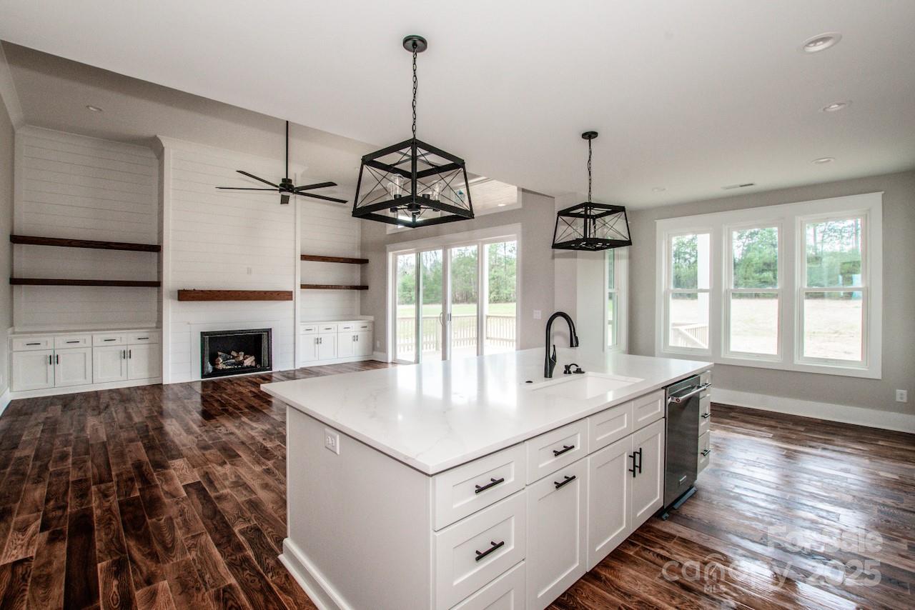 6098 Ballard Road Denver, NC 28037 - Photo 25 of 48 a kitchen with kitchen island granite countertop a stove a sink a center island and wooden floor