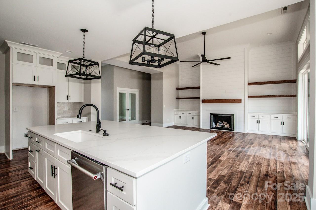 6098 Ballard Road Denver, NC 28037 - Photo 26 of 48 a kitchen with kitchen island a stove and a chandelier