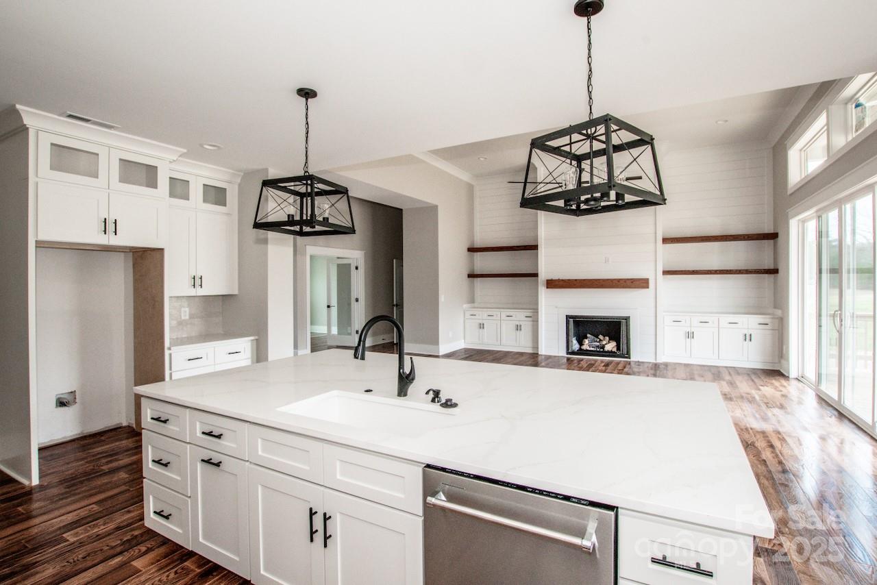 6098 Ballard Road Denver, NC 28037 - Photo 27 of 48 a kitchen with a sink stainless steel appliances and a chandelier