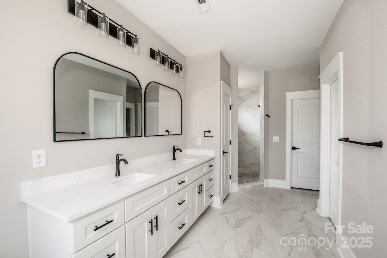 6098 Ballard Road Denver, NC 28037 - Photo 35 of 48 a bathroom with double vanity sinks and a mirror