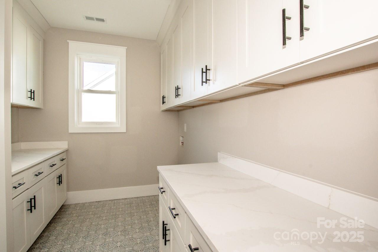6098 Ballard Road Denver, NC 28037 - Photo 39 of 48 a view of a kitchen with white cabinets and a wooden floor
