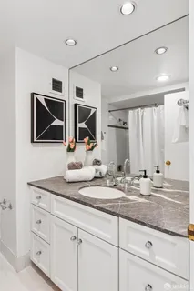 a bathroom with a granite countertop sink and a mirror