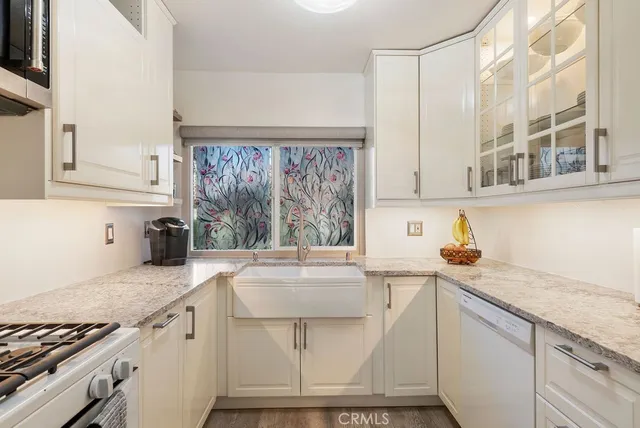 a kitchen with stainless steel appliances granite countertop a sink stove and cabinets