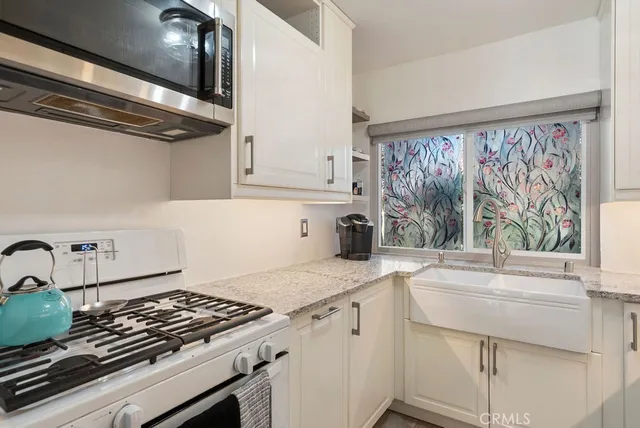 a kitchen with a stove a sink and cabinets