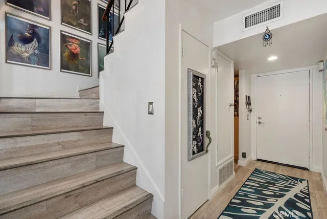 a view of a hallway with wooden floor and staircase