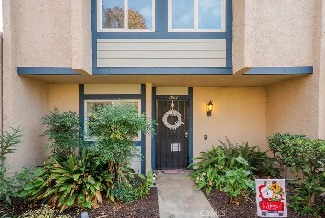 a front view of a house with plants