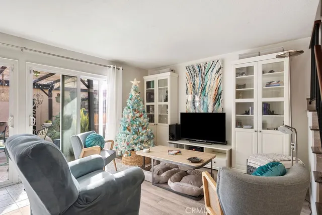 a living room with furniture a flat screen tv and a floor to ceiling window