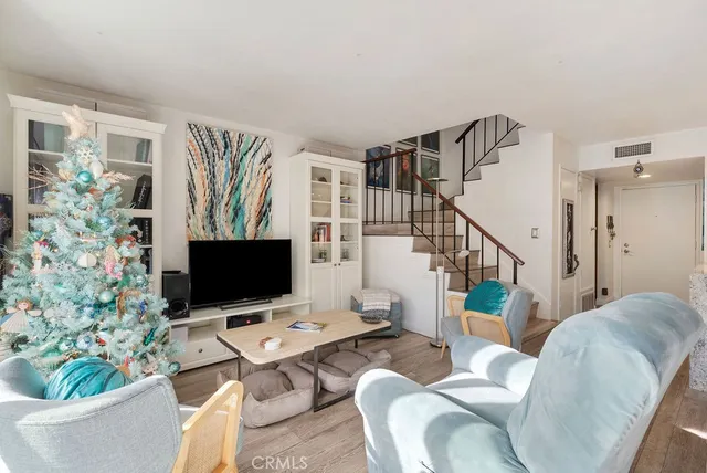 a living room with furniture a flat screen tv and a potted plant