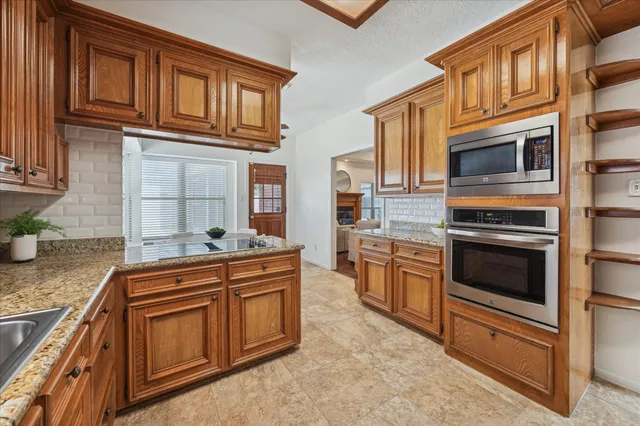 a kitchen with stainless steel appliances granite countertop a stove and cabinets