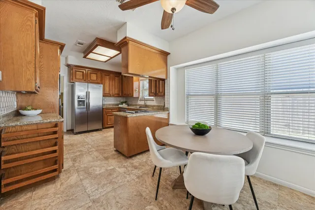 a kitchen with stainless steel appliances kitchen island granite countertop a table and chairs
