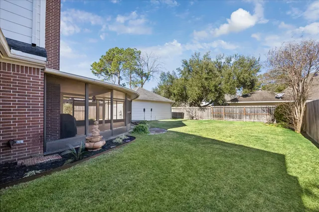 a view of a house with backyard and a tree