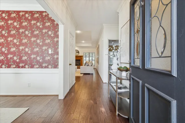 a view of a hallway with wooden floor and staircase