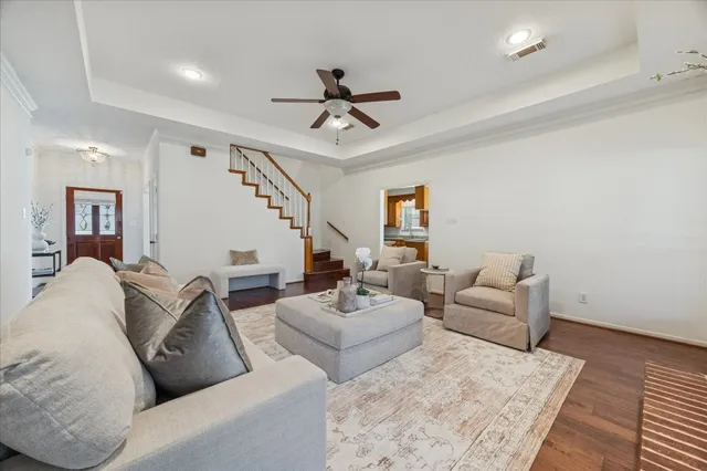 a living room with furniture and a ceiling fan