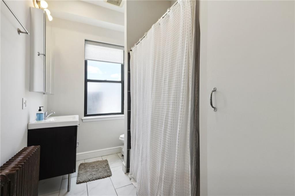5259 Carnegie Street Lawrenceville, PA 15201 - Photo 26 of 50 a bathroom with a sink a mirror and a window