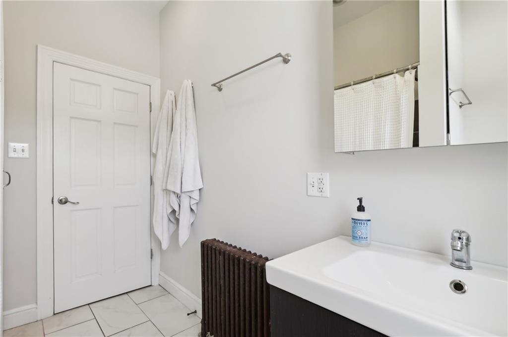 5259 Carnegie Street Lawrenceville, PA 15201 - Photo 27 of 50 a bathroom with a sink a mirror and shower