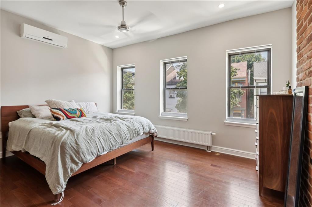 5259 Carnegie Street Lawrenceville, PA 15201 - Photo 31 of 50 a bedroom with a bed painting and wooden floor