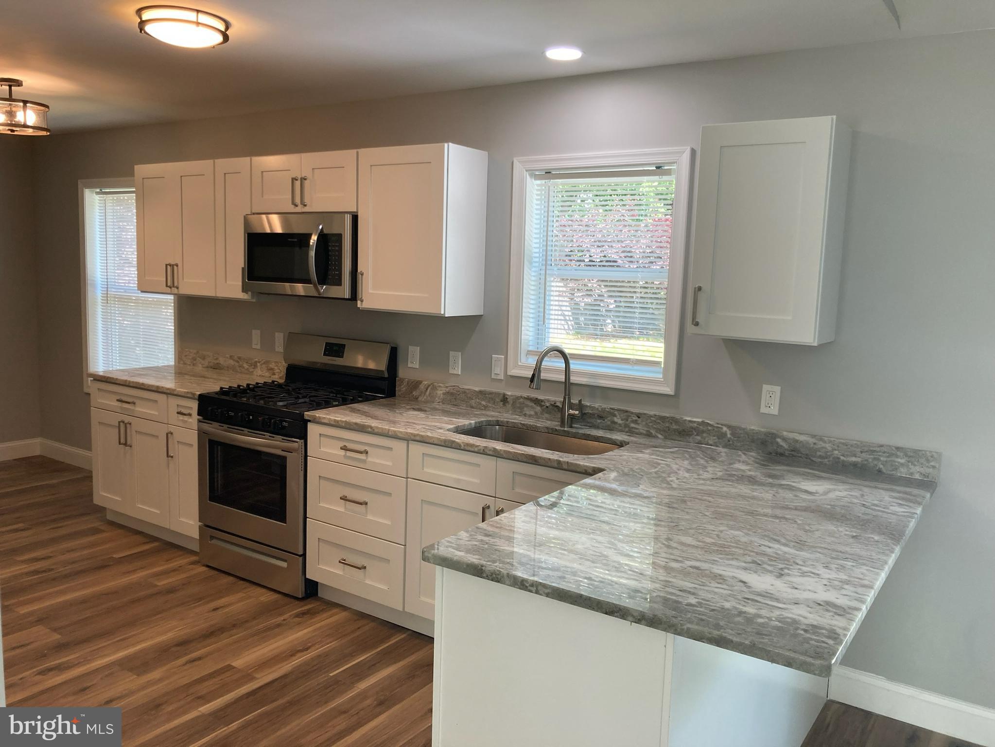 9 King Drive Bridgeton, NJ 08302 - Photo 10 of 16 a kitchen with granite countertop a sink stainless steel appliances and white cabinets