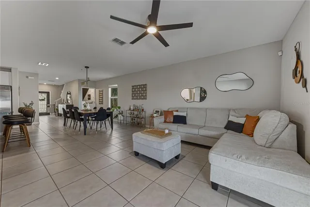 a living room with furniture and a ceiling fan