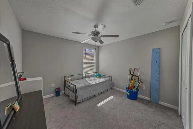 a bedroom with a bed and a flat tv screen on dresser
