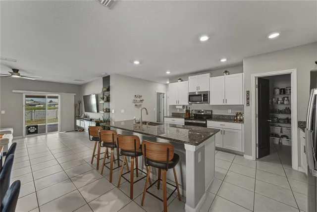 a kitchen with a refrigerator and a stove top oven