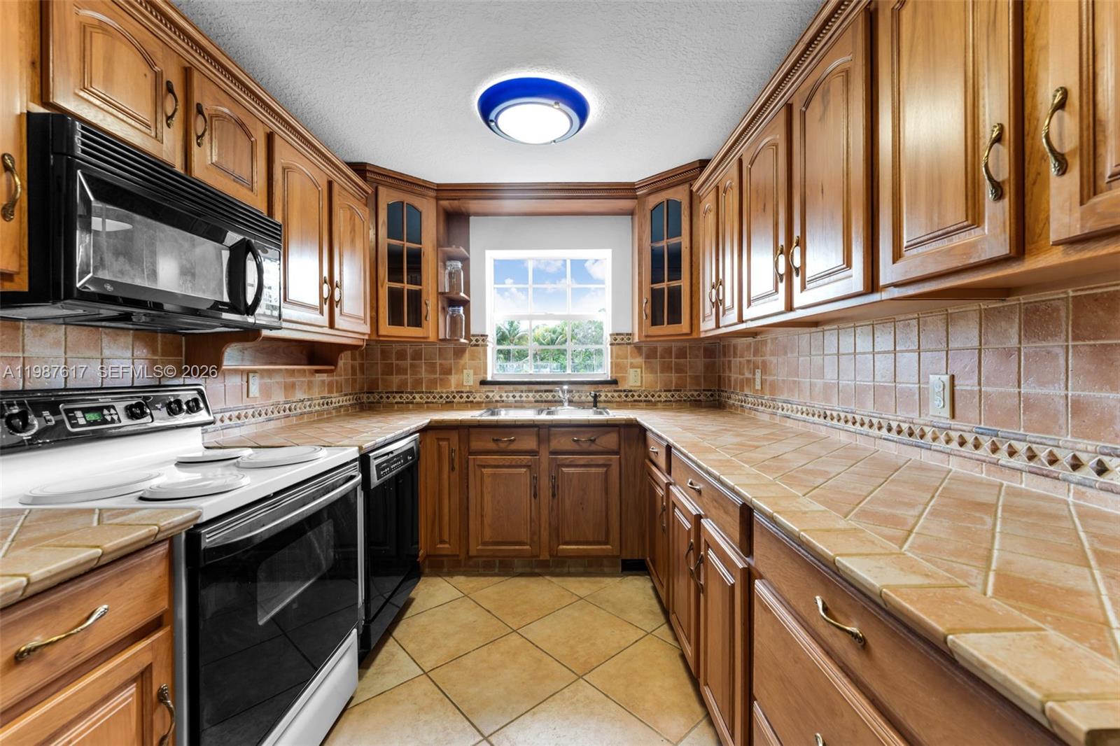 9840 Southwest 60th Street Miami, FL 33173 - Photo 11 of 37 a kitchen with stainless steel appliances granite countertop a stove and a sink