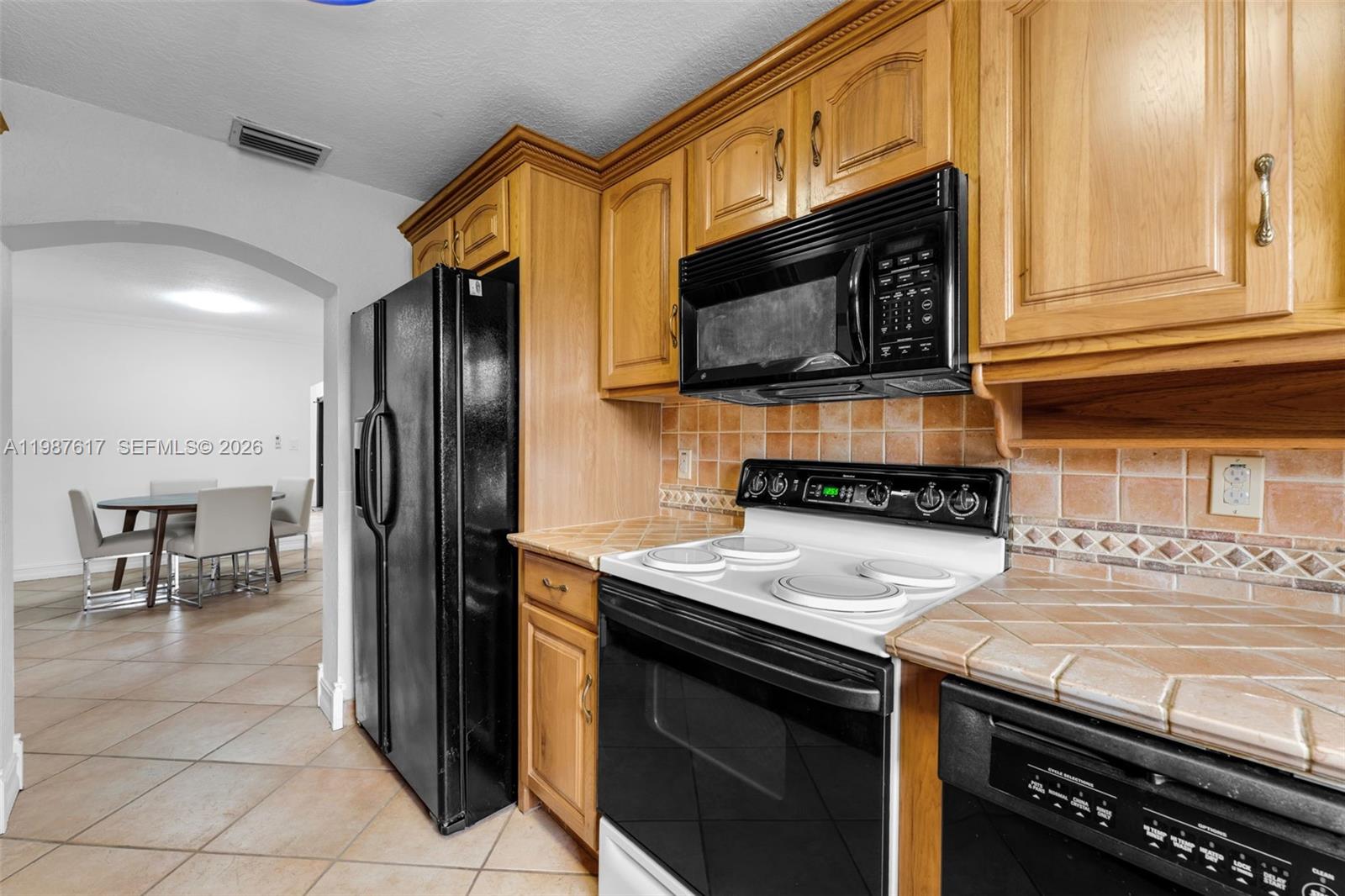 9840 Southwest 60th Street Miami, FL 33173 - Photo 12 of 37 a kitchen with stainless steel appliances a stove a sink and a microwave