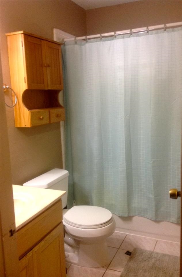 10203 Center Road Laredo, TX 78045 - Photo 2 of 9 a bathroom with a toilet a sink and curtain