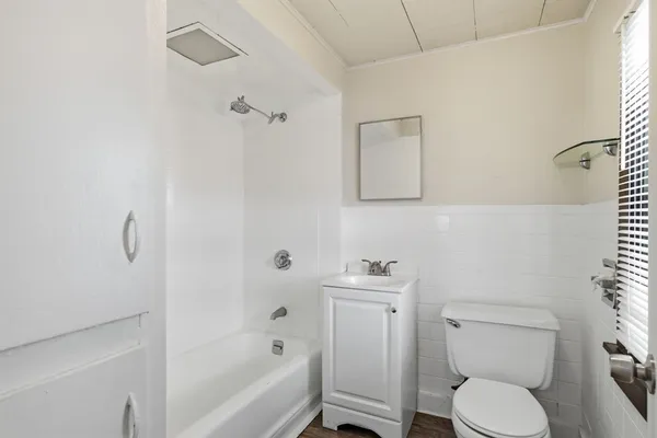 a white toilet sitting next to a bath tub
