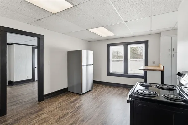 a kitchen with a refrigerator and wooden floor