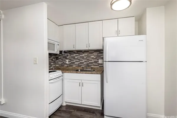 a kitchen with white cabinets and white appliances