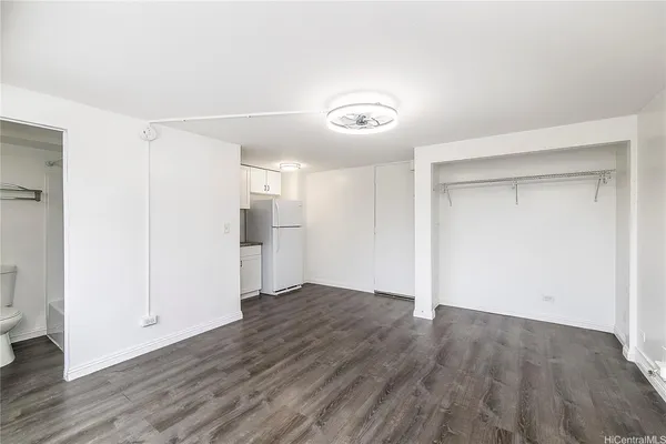 a view of an empty room with wooden floor