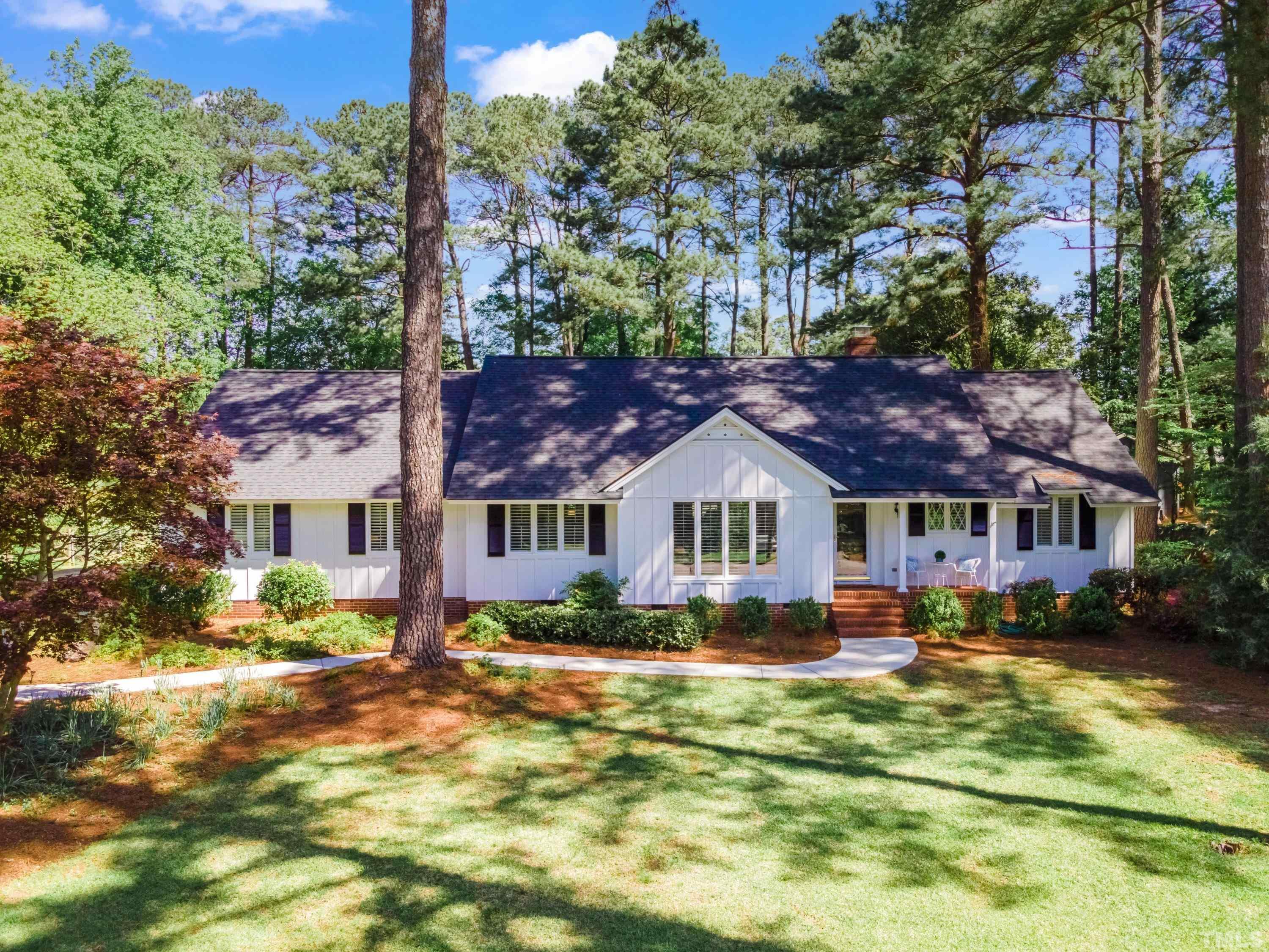 1109 Country Ridge Drive Raleigh, NC 27609 - Photo 1 of 64 a front view of a house with a yard table and chairs