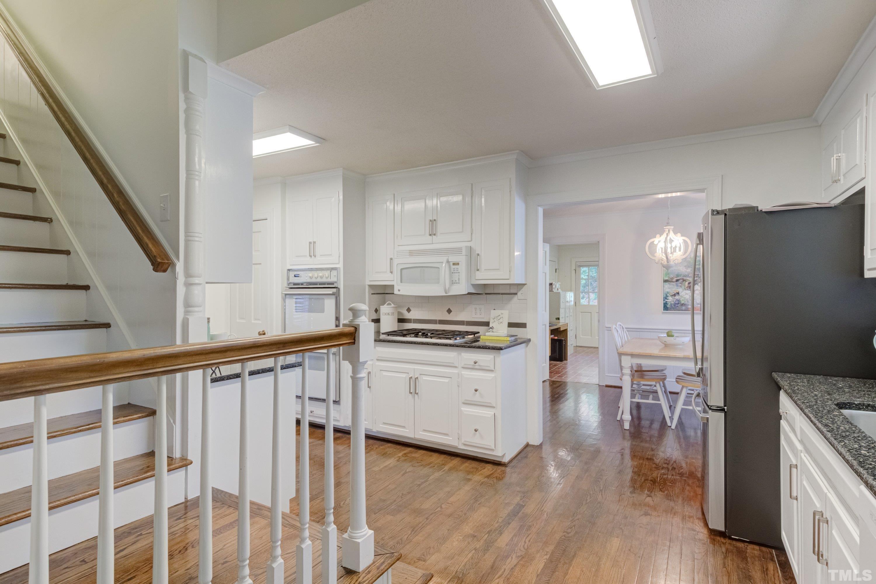 1109 Country Ridge Drive Raleigh, NC 27609 - Photo 16 of 64 a kitchen with granite countertop white cabinets and stainless steel appliances