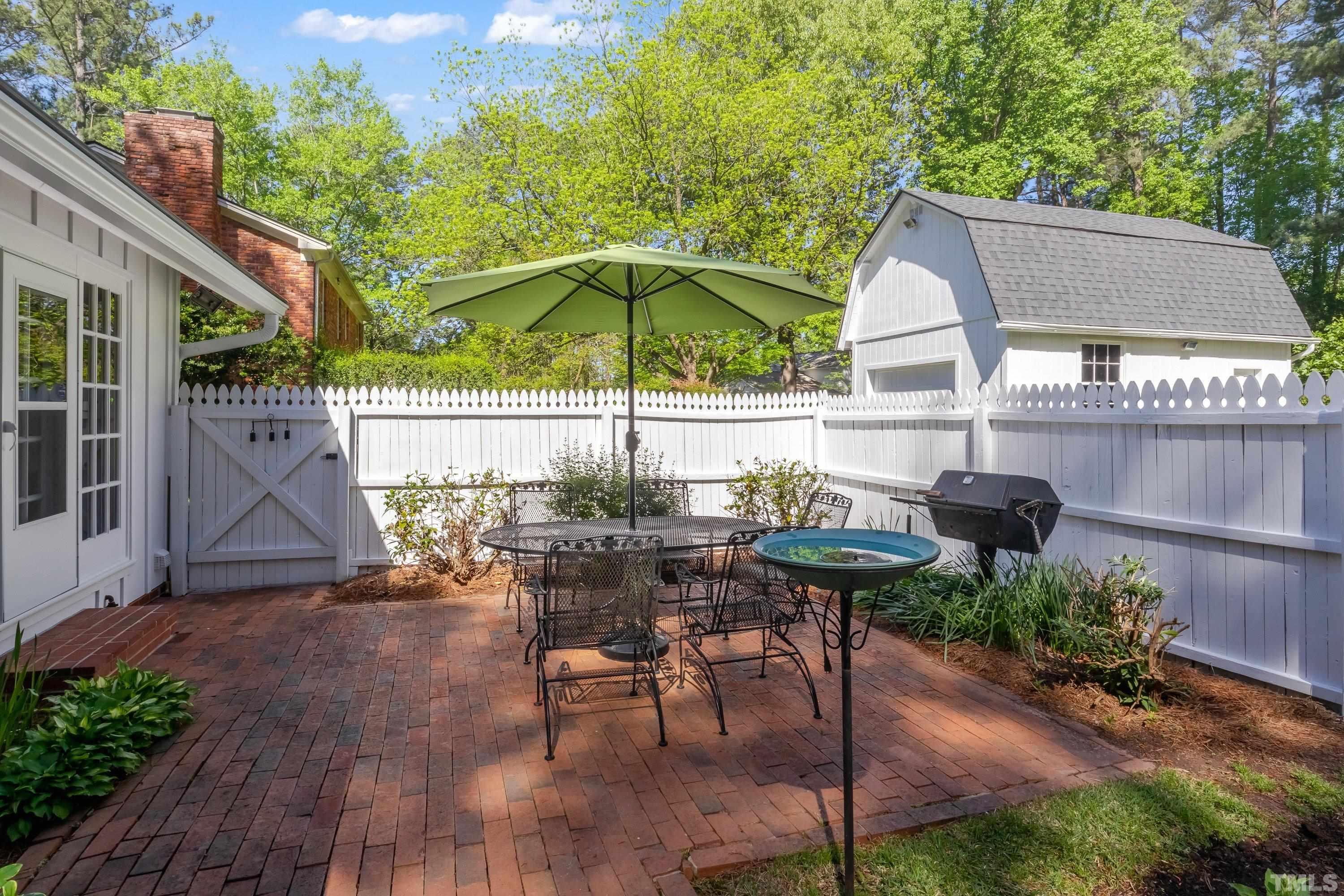 1109 Country Ridge Drive Raleigh, NC 27609 - Photo 47 of 64 a view of a patio with table and chairs under an umbrella