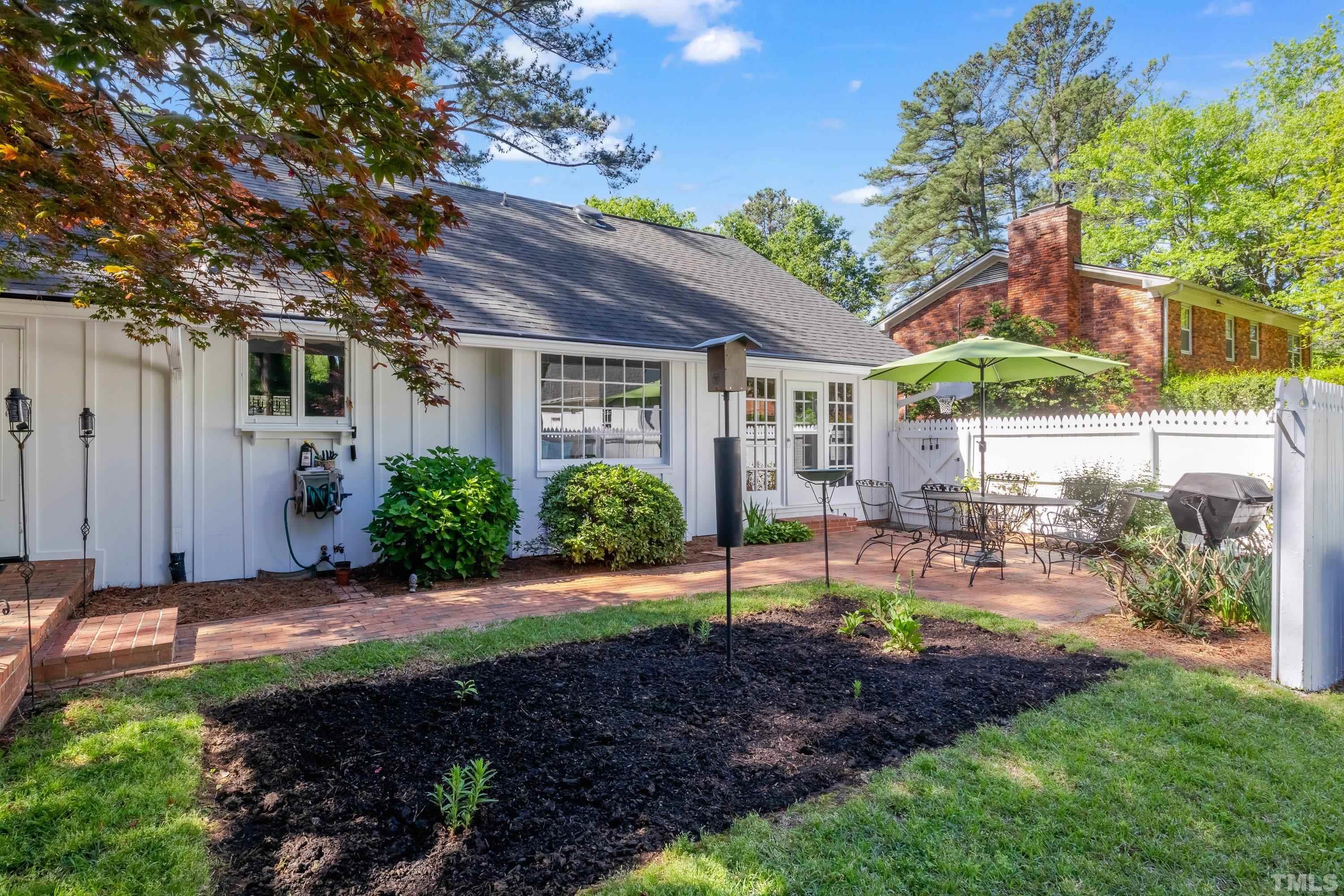 1109 Country Ridge Drive Raleigh, NC 27609 - Photo 48 of 64 a view of a patio with table and chairs potted plants and large tree