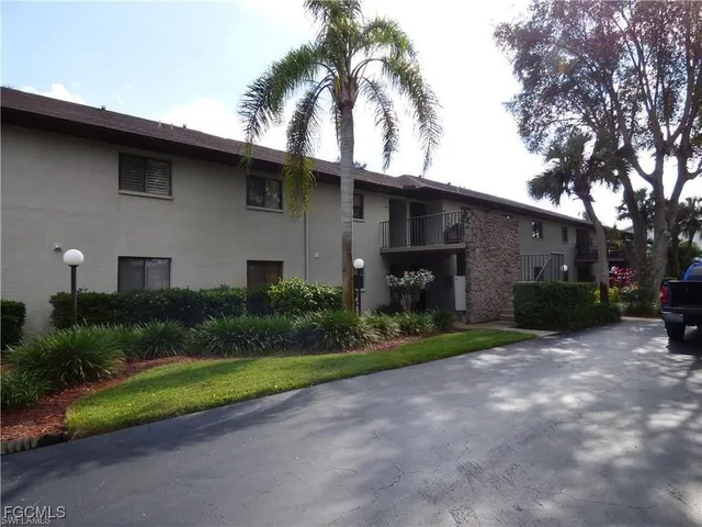 a front view of a house with a yard and potted plants