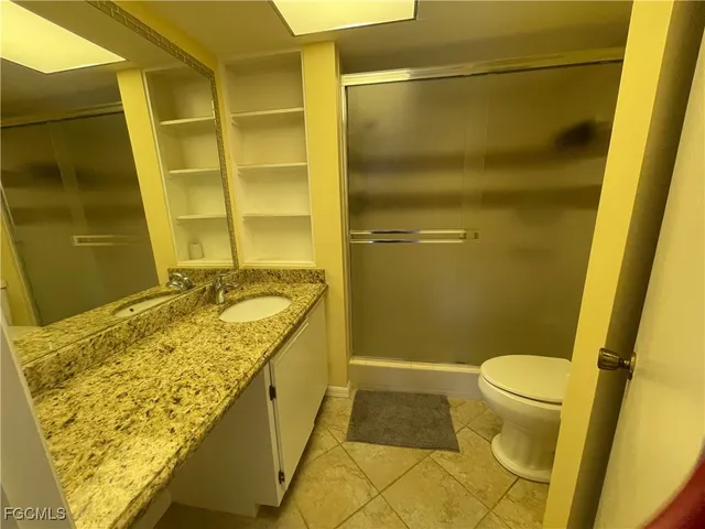 a bathroom with a granite countertop sink toilet and shower