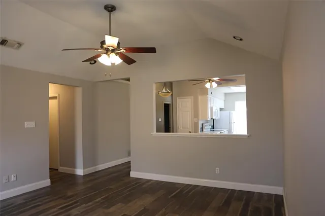 a view of a room with wooden floor and a ceiling fan