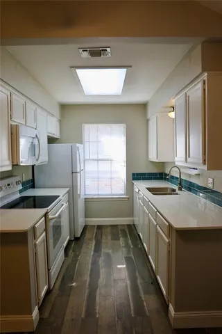 a kitchen with a sink stove and cabinets
